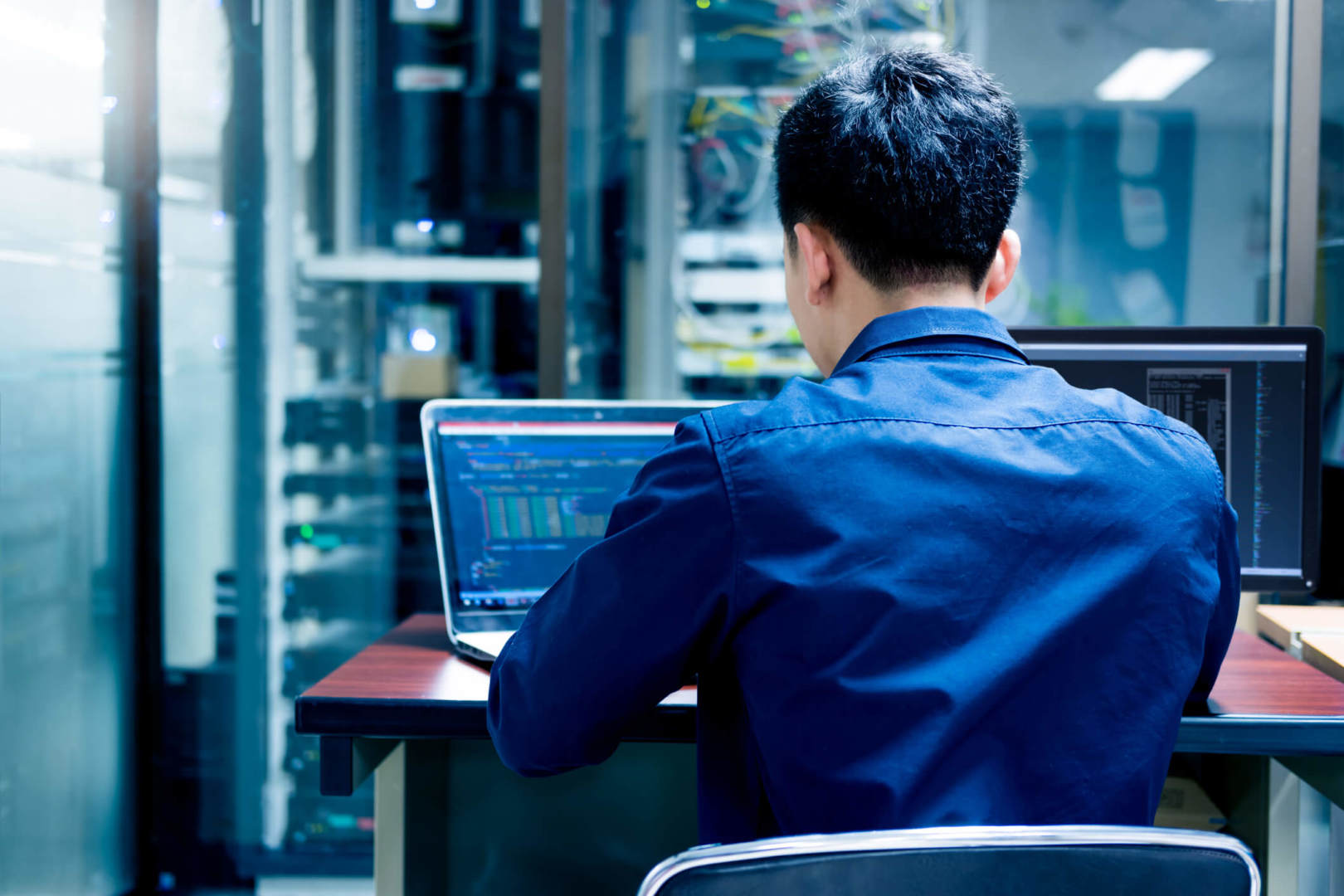 Young cyber professional with multiple screen set-up