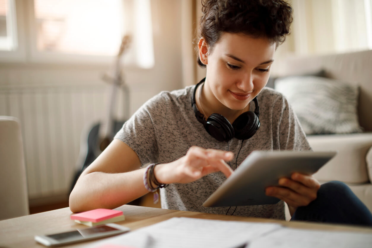 Smiling young woman using digital tablet at home