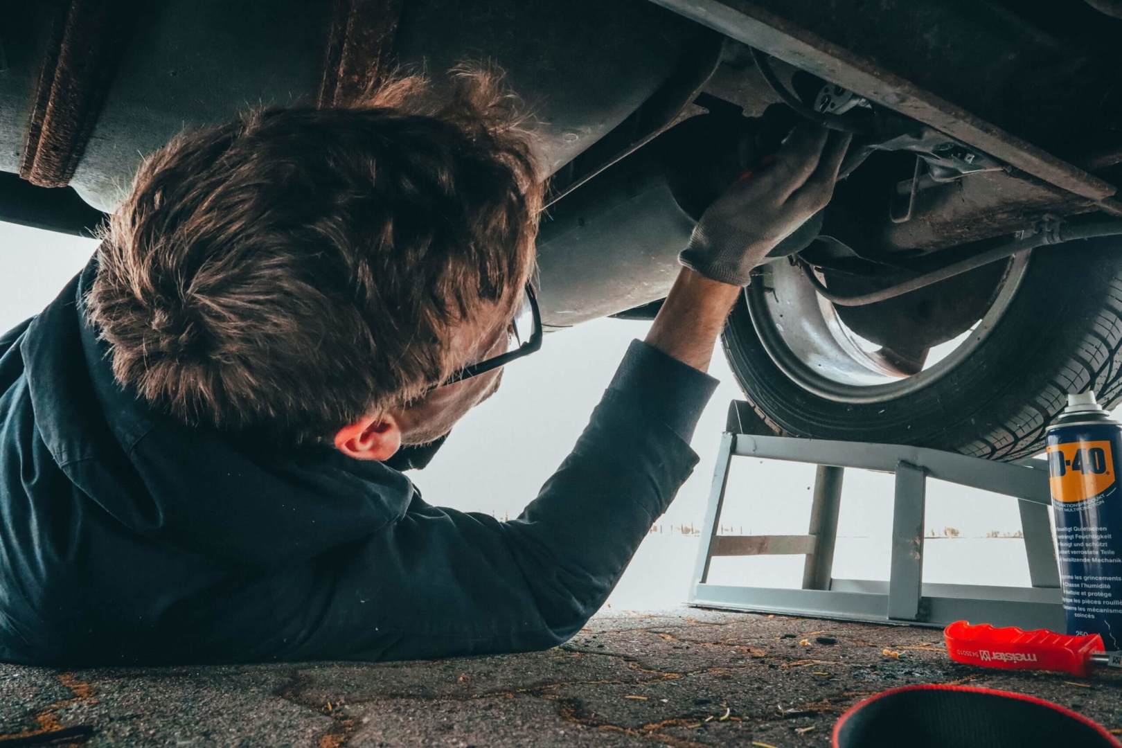 man fixing underside of car